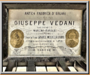 Das Firmenschild gibt keine Auskunft über das Baujahr der Orgel. Wann und welche internationale Ausstellung in Neapel und Kairo stattgefuden haben ist nicht nachgewiesen. Bei anderen Orgeln von Vedani heisst die Firma Talamona e Vedani.
